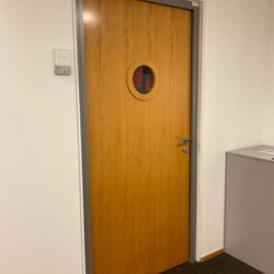 Porte bois pleine avec hublot sur cadre métallique